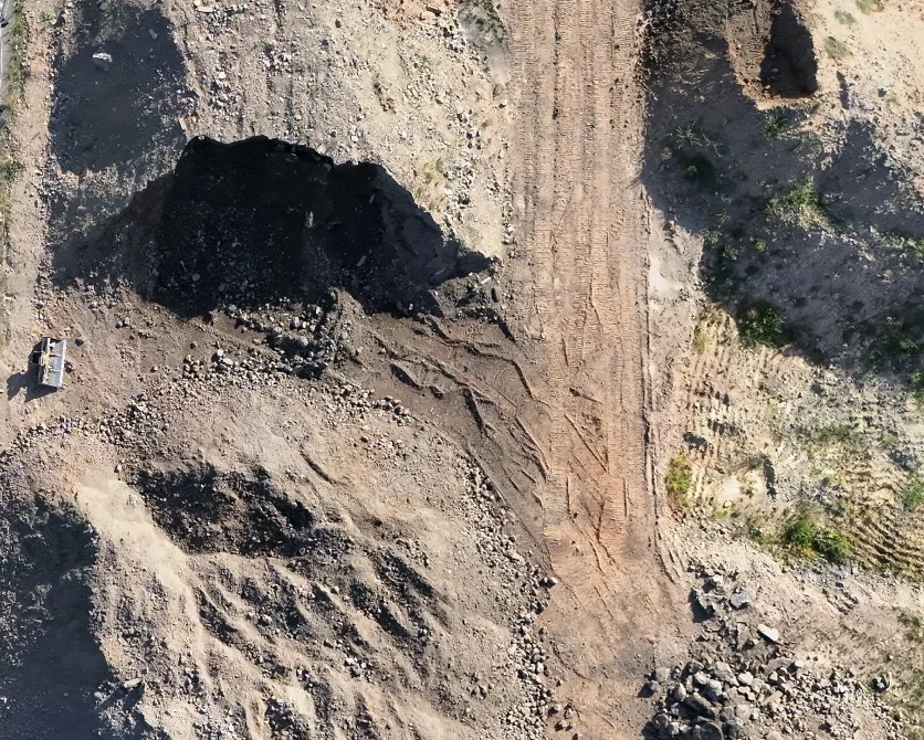 Ergänzende Luftaufnahme einer Baustelle mit Erd- und Materialflächen